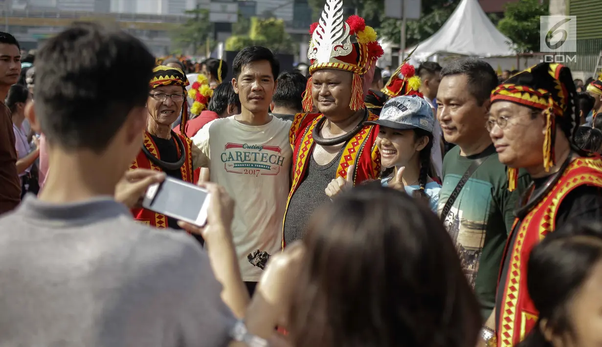 Sejumlah peserta parade seni budaya mengenakan pakaian adat dan atribut Kepulauan Nias saat Car Free Day di Kawasan Jalan Sudirman, Jakarta, Minggu (4/3). (Liputan6.com/Faizal Fanani)