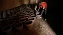 Pekerja mengeringkan pot tanah liat sebelum memajangnya untuk dijual di bengkel tembikar di Khartoum, Sudan, Kamis (27/6/2019). (AP Photo/Hussein Malla)