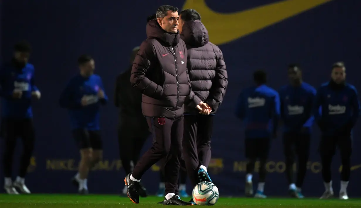 Pelatih Barcelona, Ernesto Valverde (tengah) melihat para pemainnya mengikuti sesi latihan di Joan Gamper Sports City di Sant Joan Despi (17/12/2019). Barcelona akan bertanding melawan Real Madrid dalam laga El Clasico di Camp Nou. (AFP/Lluis Gene)