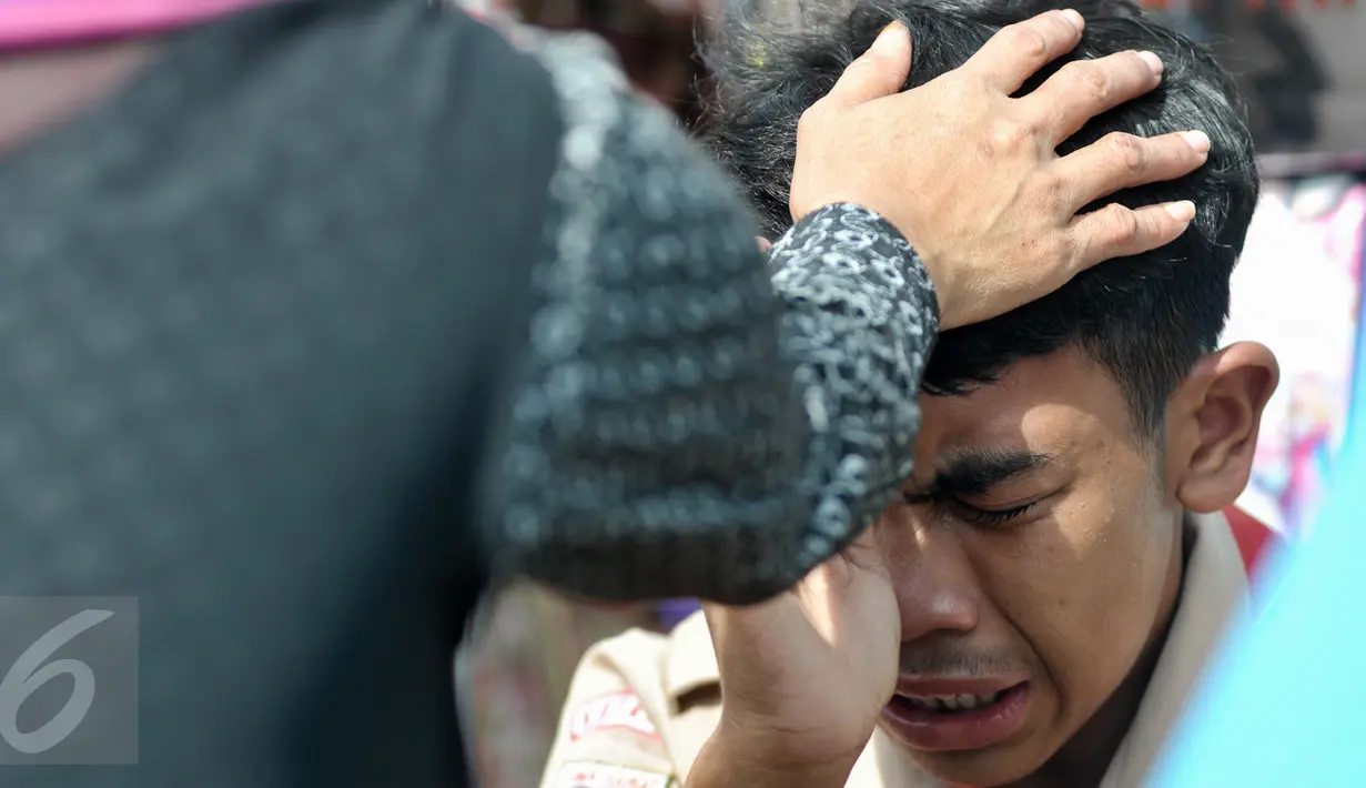 Anggota Kwarnas Gerakan Pramuka menangis sambil membasuh kaki ibunya di Taman Wiladatika Cibubur, Jakarta, Rabu (21/12). Memperingati Hari Ibu 2016, Kwarnas Gerakan Pramuka menggelar kegiatan "Membasuh Kaki Ibu" secara massal . (Liputan6.com/Yoppy Renato)