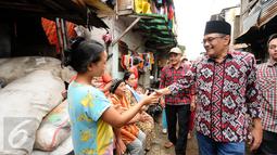 Cawagub petahana, Djarot Syaiful Hidayat menyalami warga saat sosialisasi di kawasan Pademangan VIII, Jakarta, Kamis (23/3). Selain sosialisasi dengan warga, Djarot juga menyerap keluhan warga sekitar. (Liputan6.com/Helmi Fithriansyah)  