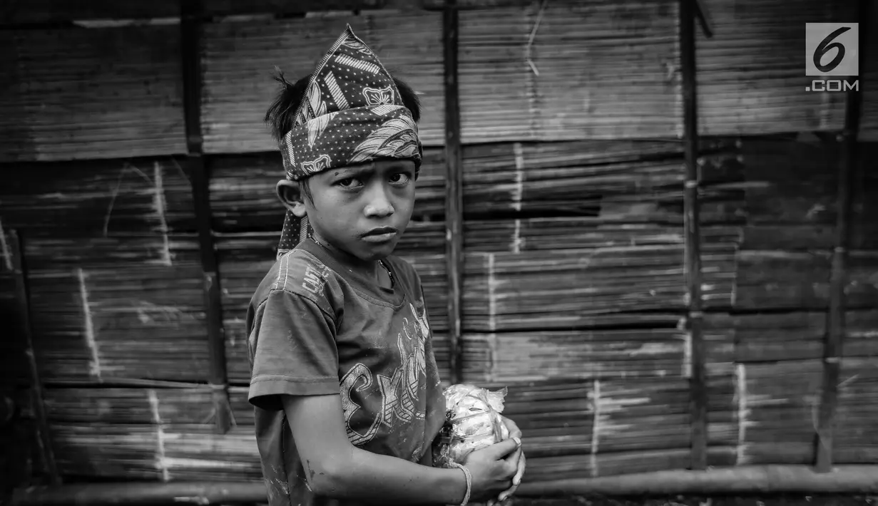 Seorang anak Suku Baduy Luar pose di depan rumah yang dibangun dengan tenda di lokasi bekas kebakaran Kampung Cisaban II, Desa Kanekes, Banten, Kamis (1/6). Kebakaran pada pekan lalu yang menghanguskan 83 rumah Suku Baduy Luar. (Liputan6.com/Fery Pradolo)