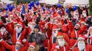 Peserta mengenakan kostum Sinterklas ikut serta dalam kegiatan amal Santa's Fun Run di Riga, Latvia, Minggu (8/12/2019). Ini merupakan acara amal yang pesertanya bersenang-senang dengan berlari atau berjalan kaki untuk mengumpulkan dana bagi anak-anak di rumah sakit Latvia. (Gints Ivuskans/AFP)