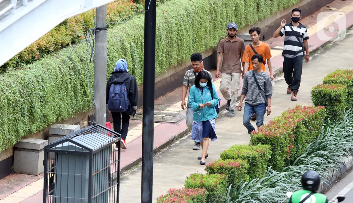 Warga berjalan di trotoar Jalan HR Rasuna Said, Jakarta, Kamis (7/1/2021). Untuk menyeragamkan kebijakan pengendalian COVID-19, Gubernur DKI Jakarta akan segera menerbitkan Pergub untuk Pemberlakuan Pembatasan Kegiatan Masyarakat (PPKM) pada 11-25 Januari 2021. (Liputan6.com/Helmi Fithriansyah)