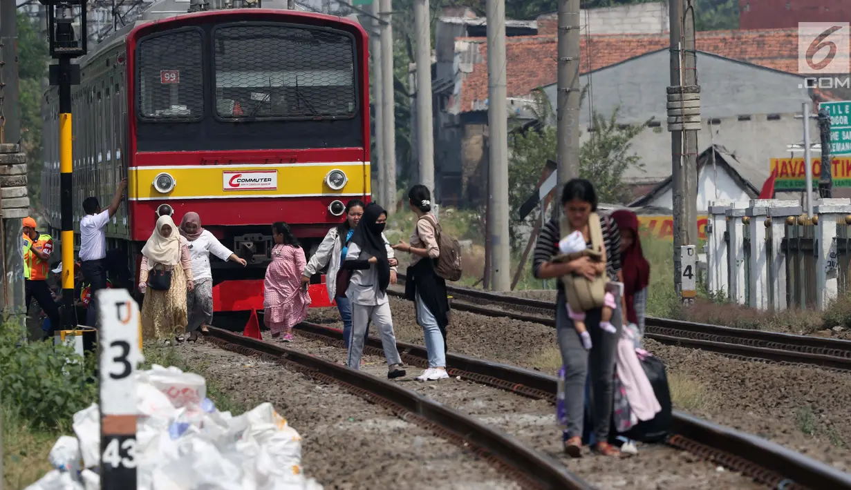 Sejumlah penumpang KRL Commuter Line terpaksa berjalan kaki menuju Stasiun Bojonggede, Bogor, Jawa Barat, Minggu (4/8/2019). Padamnya listrik di wilayah Jabodetabek mengakibatkan perjalanan KRL Commuter Line terhenti. (Liputan6.com/Helmi Fithriansyah)
