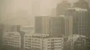 Kabut dan debu menyelimuti gedung-gedung di Beijing, Jumat, 10 Maret 2023. Pencakar langit menghilang ke dalam kabut dan kualitas udara anjlok saat ibu kota China diselimuti badai debu dan polusi berat pada Jumat. (AP Photo/Mark Schiefelbein)