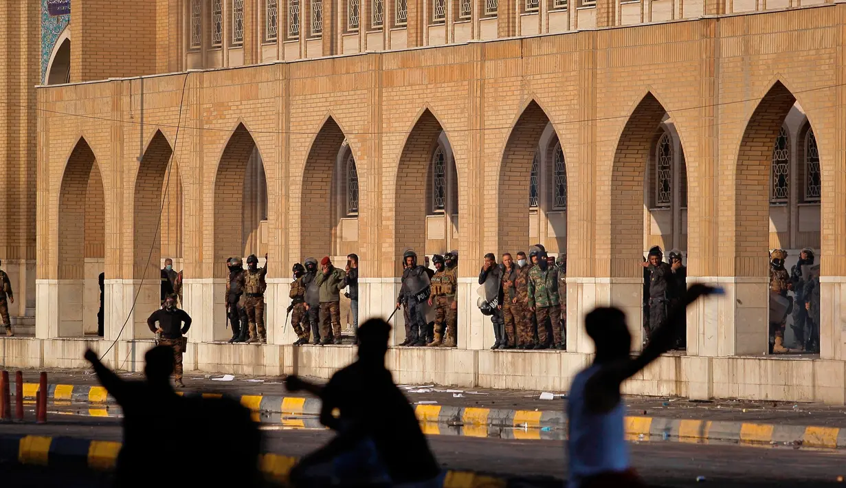 Pasukan keamanan berusaha membubarkan demonstran antipemerintah selama bentrokan di Najaf, Irak, Kamis (28/11/2019). Kerusuhan di Ibu Kota dan wilayah selatan Irak terus meningkat setelah pembakaran gedung Konsulat Iran. (AP Photo/Anmar Khalil)