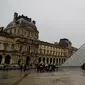 Orang-orang mengantre di depan Louvre Pyramide di Paris pada Minggu (1/3/2020). Louvre, museum yang paling banyak dikunjungi di dunia, ditutup sementara untuk pengunjung setelah para staf mengutarakan kecemasan dan ketakutannya tertular virus corona tipe baru, Covid-19. (Thomas SAMSON/AFP)