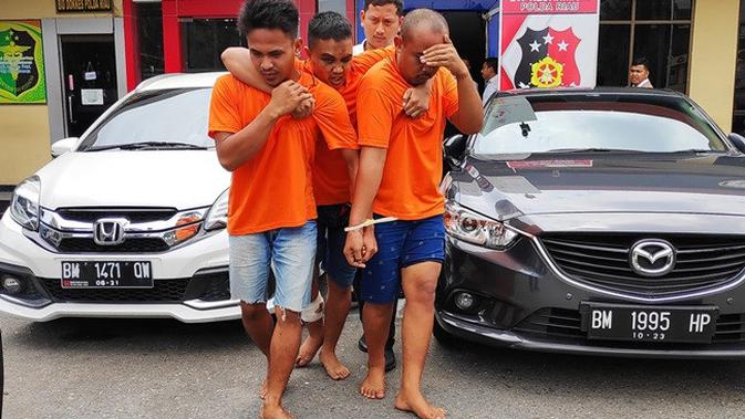 Otak pelaku perampokan rumah janda beranak tiga di Riau dipapah pelaku lainnya karena ditembak polisi. (Liputan6.com/M Syukur)
