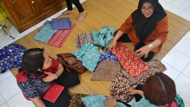 Pecinta batik berdiskusi dengan pengelola toko, memilih batik yang akan dipinang. (Foto: Liputan6.com/Muhamad Ridlo)