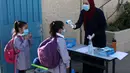 Seorang pelajar menjalani pemeriksaan suhu tubuh di sekolah pada hari pertama tahun ajaran baru di kamp pengungsi Al-Amari di Kota Ramallah, Tepi Barat (6/9/2020). Pelajar Palestina memulai tahun ajaran baru setelah belajar di rumah selama enam bulan akibat Covid-19. (Xinhua/Nidal Eshtayeh)