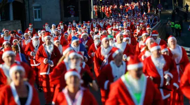 Ribuan peserta mengenakan kostum Santa Claus mengikuti balap lari Santa Dash di Liverpool, Inggris, Minggu (4/12). Lebih dari 8.000 orang diperkirakan mengikuti acara lari 5km Santa Dash yang diselenggarakan tiap tahun tersebut. (Reuters/Phil Noble)