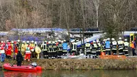 Regu penyelamat tampak bekerja di lokasi tabrakan antara dua kereta di dekat Bad Aibling, Jerman, Selasa (9/2). Kepolisian federal Jerman di lokasi mengatakan sedikitnya delapan orang tewas dan sekitar 100 lainnya cedera. (REUTERS/Michael Dalder)