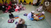 Anak-anak belajar mengaji dengan Yahya Edward yang menggunakan kostum badut di Tangerang, Banten, Kamis (29/4/2021). Mengajar ngaji menggunakan kostum badut tersebut untuk memotivasi anak-anak agar tetap semangat belajar sekaligus untuk menghibur anak didiknya. (Liputan6.com/Angga Yuniar)