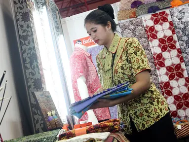 Pegawai merapikan kain batik yang dipajang pada acara Relaunching Batik Keris Online di Bekraf Habibie Festival 2017 Jakarta. Batik Keris mulai merambah ke Online hadir dengan tampilan dan fitur yang terbaru. (Liputan6.com/Pool)