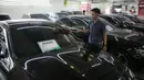 Pekerja membersihkan mobil yang dijual di Showroom Belanja Mobil, Jakarta, Senin (6/2/2023). Guna menghadirkan kebutuhan mobil bekas untuk masyarakat Indonesia saat ini, sejumlah showroom mobil bekas menerapkan penjualan konvensional serta penggunaan platform media sosial yang bisa memudahkan transaksi pembelian dan penjualan kendaraan. (Liputan6.com/Faizal Fanani)