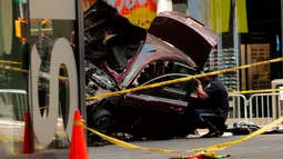 Petugas memotret kondisi mobil yang menabrak para pejalan kaki di trotoar Times Square, New York, Kamis (18/5). Para saksi mata menyebut mobil itu melaju melawan arus sebelum menabrak para pejalan kaki hingga melukai sekitar 22 orang. (Jewel SAMAD/AFP)