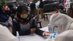 Warga mengikuti Rapid Test Covid-19 yang dilakukan oleh Dinkes Provinsi Banten di Tangerang, Selasa (21/4/2020). Rapid Test Covid-19 tersebut merupakan scrining Covid-19 di wilayah Banten agar masyarakat dapat mengetahui apakah positif atau negatif Covid-19. (Liputan6.com/Angga Yuniar)