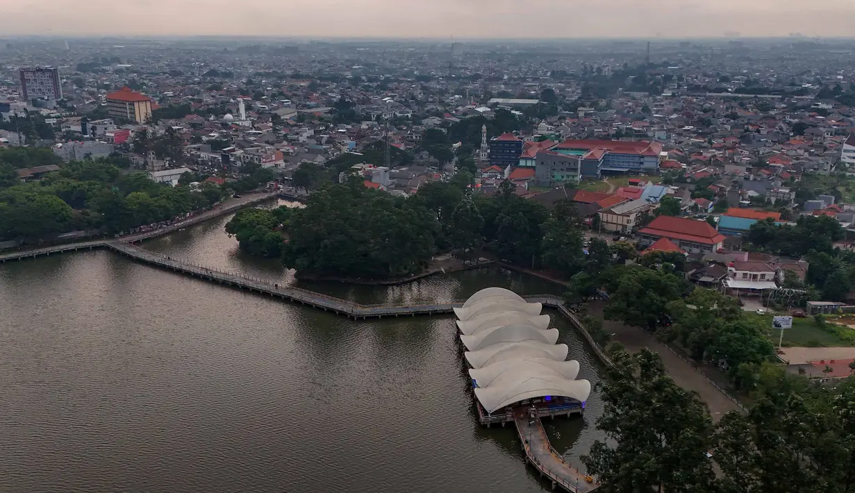Keberadaan Situ Cipondoh sejak awal diarahkan untuk mengairi lahan persawahan, menampung limpahan dari daerah aliran sungai, serta menjadi cadangan air saat musim kemarau. Tampak foto udara memperlihatkan area Situ Cipondoh di Kota Tangerang, Banten, yang tetap berfungsi sebagai kawasan konservasi air sekaligus destinasi rekreasi warga, Rabu (14/4/2026). (merdeka.com/Arie Basuki)