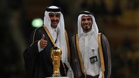 Sheikh Jassim Bin Hamad Al-Thani (kanan) bersama saudaranya Sheikh Tamim bin Hamad al-Thani dari Qatar) berpose di atas panggung dengan trofi Piala Dunia pada akhir pertandingan final Piala Dunia Qatar 2022 antara Argentina dan Prancis di Stadion Lusail di Lusail, utara Doha pada 18 Desember 2022. (AFP/Paul Ellis)