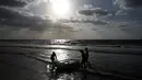 Nelayan Palestina, Mouad Abu Zeid dan teman-temannya membawa perahu yang terbuat dari botol plastik bekas di pantai Rafah, Jalur Gaza, 14 Agustus 2018. Perahu itu bisa melakukan perjalanan sejauh beberapa ratus meter dari lepas pantai. (AFP/SAID KHATIB)