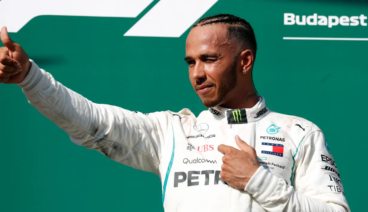 Pembalap Mercedes, Lewis Hamilton berselebrasi setelah berhasil menjuarai GP Hungaria di Sirkuit Hungaroring, Mogyorod, (29/7). Kemenangan Hamilotn menjadi yang kelima sepanjang musim ini. (AP Photo/Laszlo Balogh)