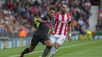 Gelandang Arsenal, Alex Oxlade-Chamberlain (kiri) berusaha menjauhi kejaran penyerang Stoke City, Jese Rodriguez, pada laga Premier League, di Britannia Stadium, Minggu (19/8/2017). (AFP/Roland Harrsson). 