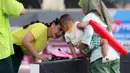 Selebritas Nagita Slavina (kiri) mendatangi putranya, Rayyanza Malik Ahmad atau yang akrab disapa Cipung saat laga tenis nomor ganda campuran Turnamen Olahraga Selebriti Indonesia (TOSI) yang digelar di GOR UNJ, Jakarta, Sabtu (15/07/2023). Gigi, sapaan Nagita Slavina, yang berpasangan dengan Ritchie Ismail atau dikenal sebagai Jeje Govinda kalah dari pasangan Gege dan Ibnu Jamil dua set langsung  (5-7, 6(2)-7(7)). (Bola.com/Abdul Aziz)