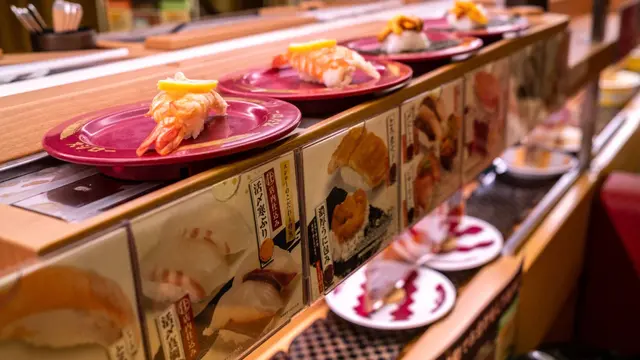 Piring sushi terlihat di ban berjalan di rantai restoran sushi Jepang.