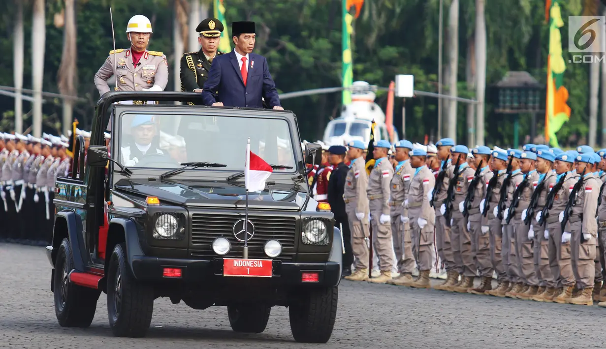 Presiden Joko Widodo (Jokowi) melakukan pemeriksaan pasukan Polri saat peringatan HUT ke-71 Bhayangkara di Monas, Jakarta, Senin (10/7). Selain itu hadir juga Wapres Jusuf Kalla serta 21 kepala polisi dari negara sahabat. (Liputan6.com/Angga Yuniar)
