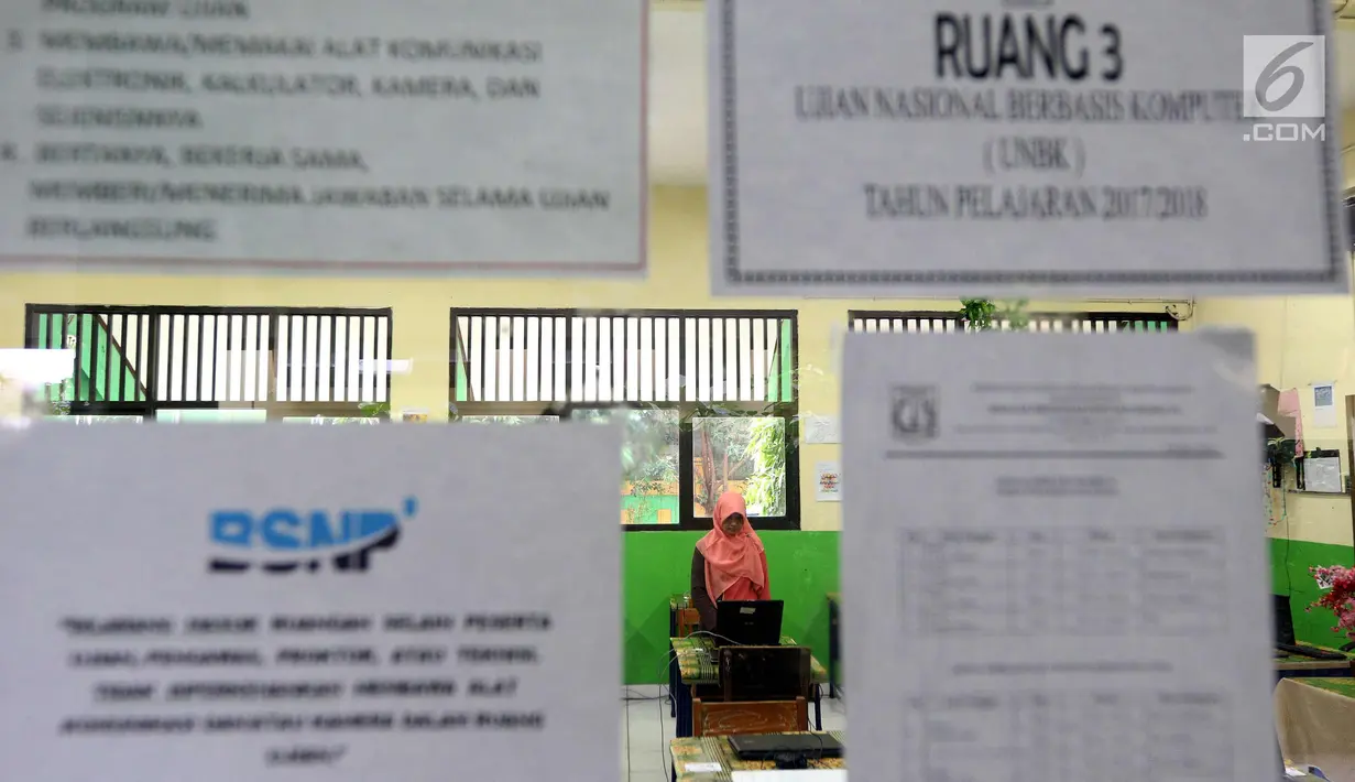 Petugas mengecek kesiapan laptop dan ruang untuk Ujian Nasional Berbasis Komputer di SMP N 34 Pademangan, Jakarta Utara, Minggu (22/4). UNBK SMP 2018 akan berlangsung mulai besok Senin (23/4). (Liputan6.com/Johan Tallo)