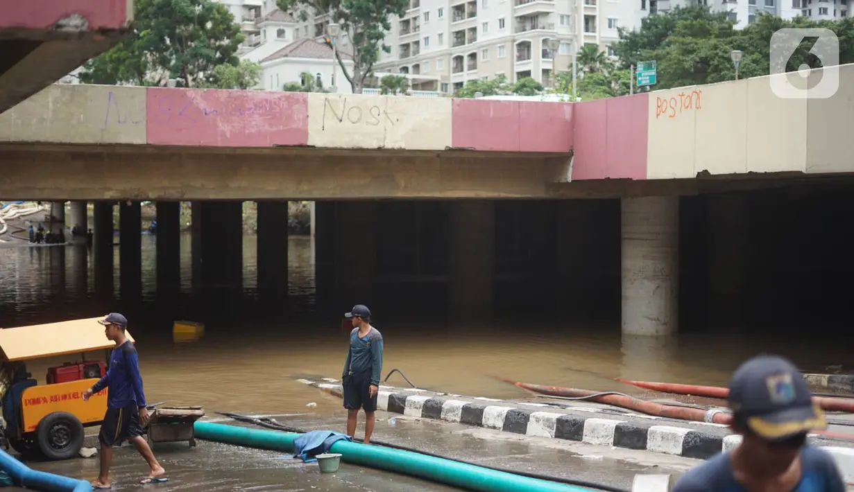 Petugas memasang pompa penyedot air di banjir yang menggenangi underpass Kemayoran, Jakarta, Senin (3/2/2020). Curah hujan tinggi menyebabkan banjir yang menggenangi kawasan tersebut lama surut sehingga menutup arus lalu lintas. (Liputan6.com/Immanuel Antonius)