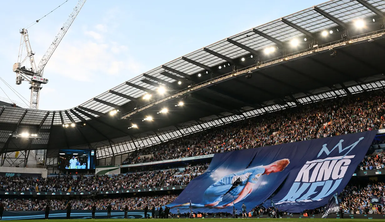 Para penonton membentangkan banner bertuliskan 'King Kev' untuk memberikan salam penghormatan setelah laga pekan ke-37 Liga Inggris 2024/2025 antara Manchester City melawan Bournemouth di Etihad Stadium, Manchester, Inggris, Selasa (21/05/2025) waktu setempat. (AFP/Paul Ellis)