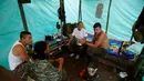 Angkatan Bersenjata Revolusioner Kolombia (FARC) Tatiana, yang sedang hamil enam bulan berbincang dengan suami dan temannya di dalam tenda jelang pengesahan kesepakatan damai dengan pemerintah Kolombia, di Yari Plains (17/9). (REUTERS/John Vizcaino)