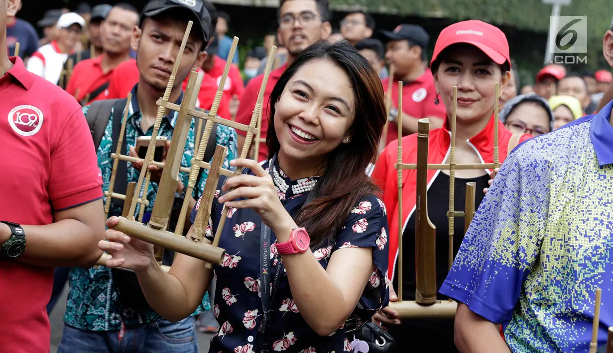 Warga memainkan angklung saat meramaikan acara 'Bangkit Indonesia' di Lokasi Car Free Day (CFD), Jakarta, Minggu (21/5). Acara memperingati Hari Kebangkitan Nasional itu dirayakan dengan pembagian 1.500 angklung. (Liputan6.com/Immanuel Antonius)