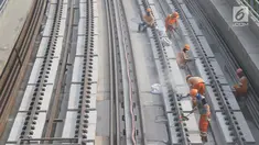 Pekerja menyelesaikan Rel Light Rail Transit (LRT) di Jakarta, Selasa (26/2). Light Rail Transit (LRT) Jabobek trase Cawang–Cibubur bakal diujicoba pada pertengahan tahun ini. (Liputan6.com/Herman Zakharia)