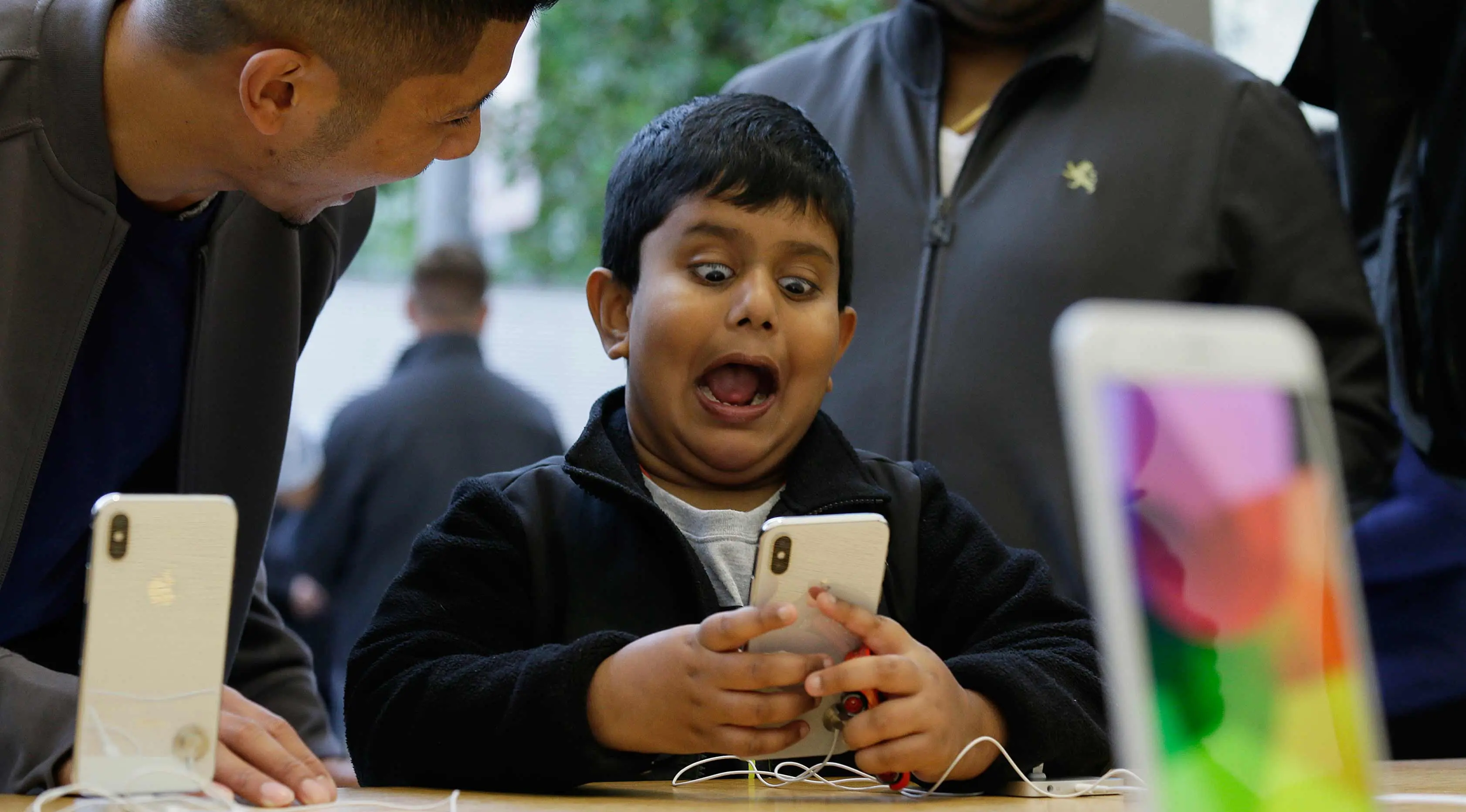 Seorang anak bermain fitur animoji iPhone X di toko Apple Union Square di San Francisco (3/11). iPhone X juga memiliki fitur terbaru Face ID yang berfungsi mendeteksi dan mengenali wajah pemilik sebagai kunci membuka perangkat. (AP Photo/Eric Risberg)
