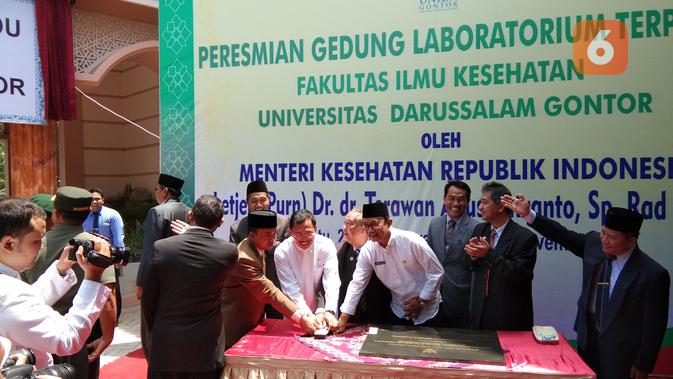 Menteri Kesehatan Republik Indonesia Terawan Agus Putranto diberikan hadiah berupa baju koko berwarna putih dan peci hitam saat mengunjungi Pondok Pesantren yang ada di Gontor. (Liputan6.com/Giovani Dio Prasasti)
