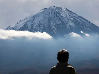 Seorang turis melihat Gunung Fuji dari Fujikawaguchiko, Prefektur Yamanashi, Jepang (1/11). Gunung Fuji adalah gunung tertinggi di Jepang, terletak di perbatasan Prefektur Shizuoka dan Yamanashi, di sebelah barat Tokyo. (AFP Photo/Behrouz Mehri)