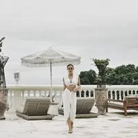 Penyanyi Indonesia Go Internasional ini tampil serba putih dengan atasan crop top dipadukan kain putih sebagai bawahan. (@agnezmo)