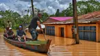 Orang-orang menaiki rakit di daerah yang terendam banjir setelah Sungai Acre meluap di Cobija, Bolivia, pada tanggal 29 Februari 2024. (STRINGER/AFP)