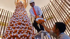 Seorang staff menyusun pohon Natal yang terbuat dari boneka beruang teddy di lobi sebuah hotel di Bangalore, India, Rabu (28/11). Ratusan boneka beruang disusun sedemikian rupa hingga membentuk pohon natal cantik. (MANJUNATH KIRAN / AFP)