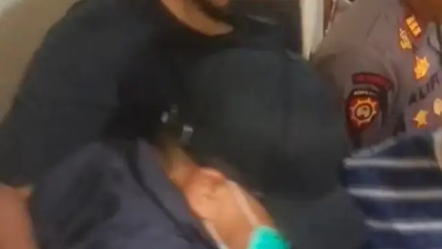 Bupati Sudewo berjaket biru, bertopi hitam dengan memakai masker dinaikan ke mobil dengan kawalan ketat aparat Polres Kudus