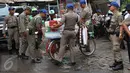 Petugas Satpol PP menahan barang dagangan milik pedagang kopi keliling yang berjualan di kawasan SCBD, Jakarta, Senin (21/11). Satpol PP merazia dan menyita dagangan yang beroperasi di kawasan tersebut. (Liputan6.com/Gempur M Surya)