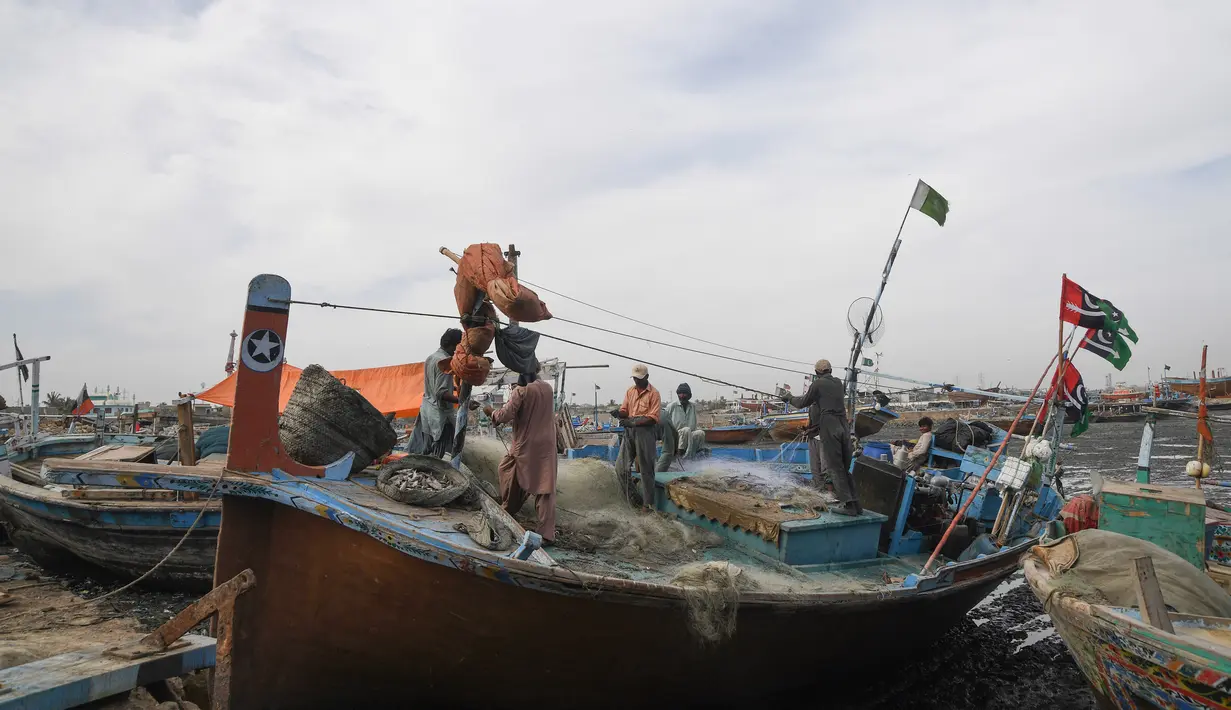 Nelayan Pakistan menyiapkan jaring ikan mereka di atas kapal di pelabuhan di Karachi (3/4). Pembuatan kapal buatan Pakistan menghasilkan ratusan kapal setiap tahun untuk memenuhi permintaan industri perikanan setempat. (AFP Photo/Asif Hassan)