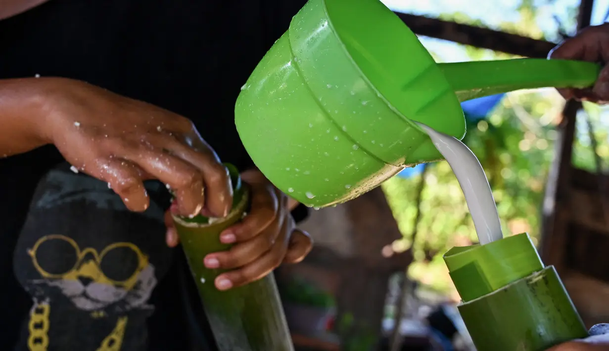 Lemang terbuat dari beras ketan yang dimasukkan ke dalam batang bambu dan dimasak di atas api arang. (CHAIDEER MAHYUDDIN/AFP)