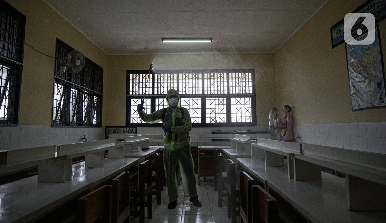 Petugas menyemprotkan disinfektan di ruang kelas SDN 08 Duri Pulo, Jakarta Pusat, Jumat (28/1/2022). Berdasarkan data Pemprov DKI Jakarta per 26 Januari 2022, ditemukan 135 orang di lingkungan sekolah terpapar Covid-19. (Liputan6.com/Faizal Fanani)