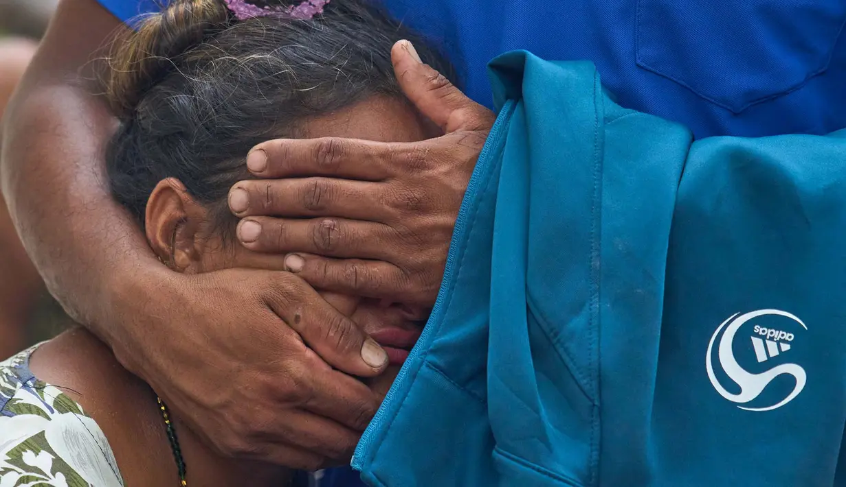 Seorang wanita menenangkan kerabatnya saat mereka menantikan kabar mengenai anggota keluarga yang hilang akibat banjir bandang di sepanjang Sungai Trishuli di distrik Nuwakot, Nepal, Rabu, 26 Agustus 2026. (Foto AP/Niranjan Shrestha)