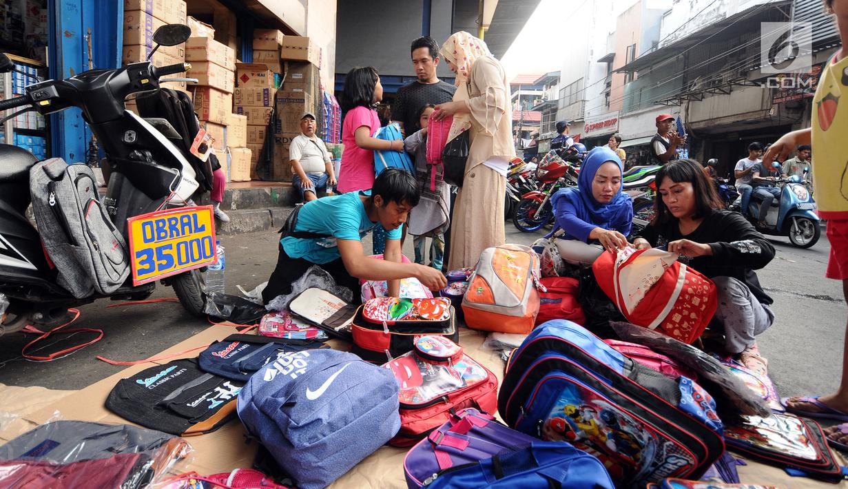 Warga memilih tas yang dijajakan pedagang kaki lima di sekitar Pasar Asemka, Jakarta, Rabu (5/7). Jelang bergantinya tahun ajaran baru, sejumlah warga berburu peralatan sekolah di kawasan Pasar Asemka Jakarta. (Liputan6.com/Helmi Fithriansyah)