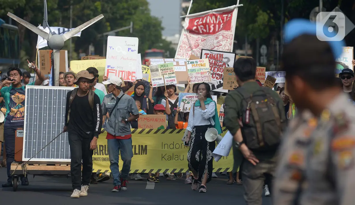 Aktivis lingkungan hidup dari berbagai LSM berjalan kaki menuju Taman Aspirasi di Istana Merdeka, Jakarta, Jumat (29/11/2019). Aktivis meminta pemerintah segera mendeklarasikan perubahan iklim yang semakin kritis. (merdeka.com/Imam Buhori)